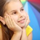 Young smiling girl with multicolor umbrella